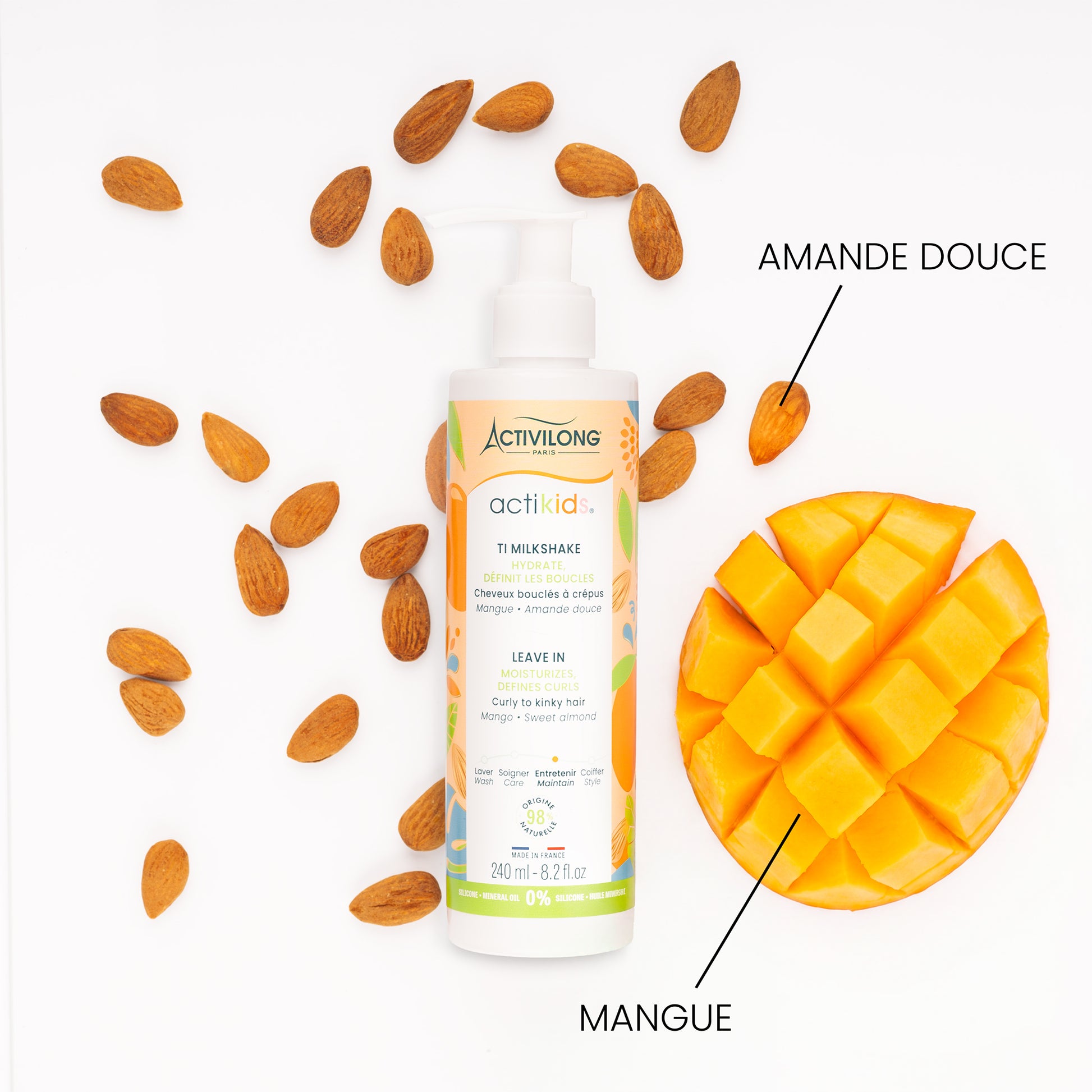 Flacon de Ti Milkshake / Leave-in Actikids entouré de ses actifs sur fond blanc : amandes douces et mangue coupée en cubes, avec les mentions « Amande douce » et « Mangue ».