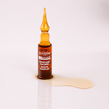 Visuel d'une ampoule du Complexe Racines Actigro avec une coulure de sérum doré sur fond clair