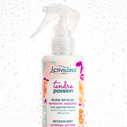 Visuel du spray Brume infusion Tendre Passion en gros plan, couvert de gouttelettes d'eau sur fond clair, évoquant la fraîcheur