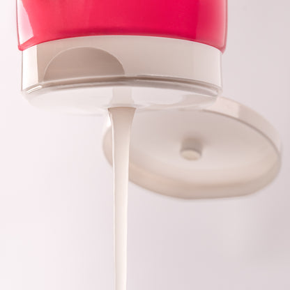 Visuel de la texture gélifiée de la Gelée Scrunching Acticurl Expert s'écoulant du bouchon sur fond clair