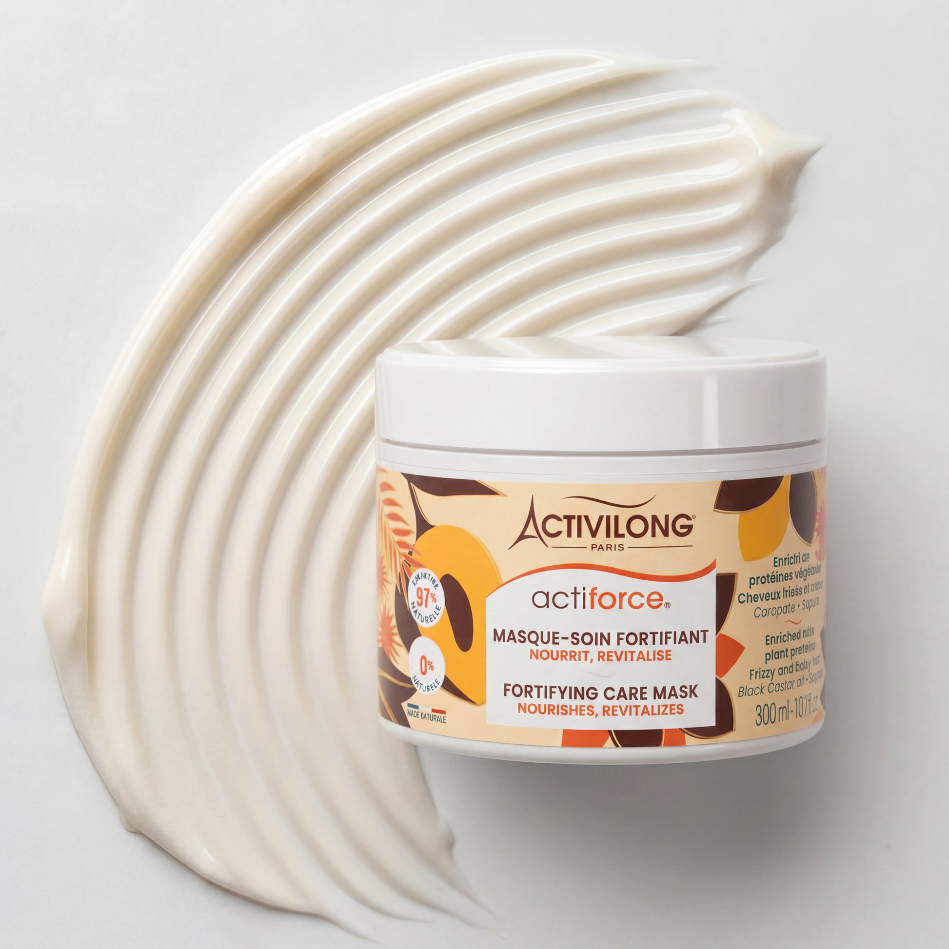 Visuel d'un Pot du Masque-Soin Fortifiant Actiforce posé sur une texture onctueuse étalée sur fond clair