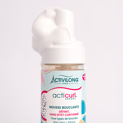 Visuel d'un Flacon de la Mousse Bouclante Acticurl Expert surmonté d'une noisette de mousse aérienne sur fond clair